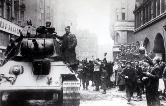 Československý tank 30. dubna 1945 na přístupu k Sýkorovu mostu (vpravo dům na ulici 28. října č 18), ještě před útokem na most.